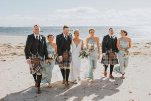 锡米尔The Waterside Hotel的海滩上的新娘和新郎以及他们的婚礼派对