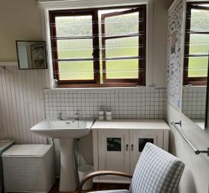 自然谷Stok&Hoed的一间带水槽、窗户和椅子的浴室