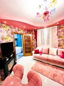 里加Bierini Park Studio的客厅配有粉色家具和吊灯。