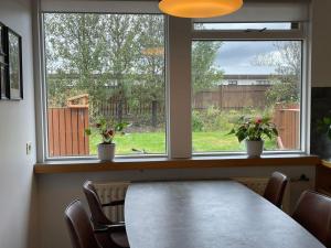 NjarðvíkAirport Comfort Home的一间带桌子和2个窗户的用餐室