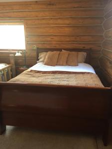 维勒蒙特Valemount Mountain Retreat Guesthouse的木墙客房的一张床位