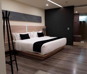 克雷塔罗杜蒙酒店的卧室配有白色大床和黑白色枕头