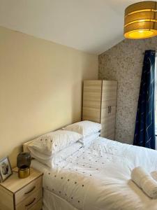 伦敦Holiday Home in Walthamstow的一间卧室配有床、梳妆台和台灯。