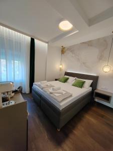 萨格勒布利迪雅旅馆的一间卧室配有一张带绿色枕头的大床