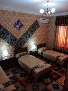 希瓦Khiva Bibimariyam的酒店客房带两张床和地毯