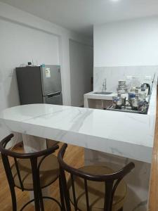 塔克纳Apartamentos Cristo Rey.的厨房配有白色的桌子和两把椅子
