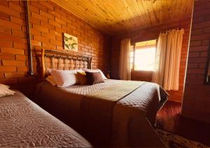 邦雅尔丁-达塞拉法泽恩达圣塔里塔农场旅舍的一间卧室设有两张床和砖墙
