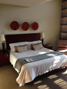 马加利斯堡马罗彭精品酒店 的一间卧室配有一张大床,墙上挂着两顶帽子