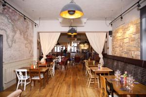 伦敦库克船长宾馆的餐厅设有木桌和椅子,拥有砖墙
