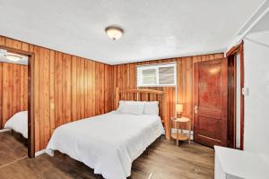 埃斯卡诺巴Eagles Nest Motel Unit 2的一间卧室设有一张床和木墙
