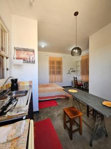 卡兰卡斯Chalé Arcos do Sol - Carrancas的一间客房内配有床和桌子的房间