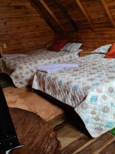 乔阿奇Cabañas del bosque的木制客房内的一间卧室,配有一张床