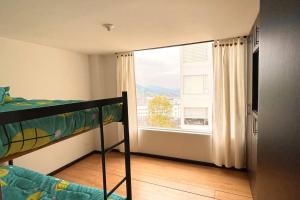 马尼萨莱斯Av santander apartamento perfecta ubicación的一间卧室设有一张双层床和大窗户。