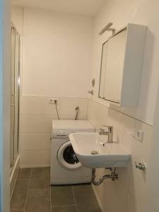 格奥尔格斯马林许特Ferienwohnung 309 am Kasinopark的白色的浴室设有洗衣机和水槽。