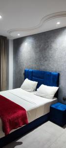 丹吉尔Les Belles Appartements Family Only的一张带蓝色床头板和红色毯子的床
