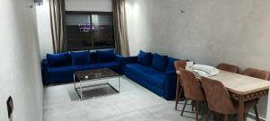 丹吉尔Les Belles Appartements Family Only的客厅配有蓝色的沙发和桌子
