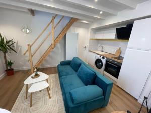 拉罗谢尔Le Cordelier-Proche marché central et vieux port-wifi haut débit-Netflix的一间带蓝色沙发的客厅和一间厨房