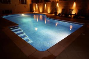 圣赫利尔泽西萨伏伊酒店的夜间游泳池,灯光照亮