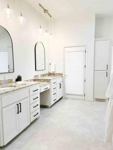 拉伯克NEW Magnolia Mansion-4400sqft Hot Tub & 2 Game Rms的白色的浴室设有2个水槽和2面镜子