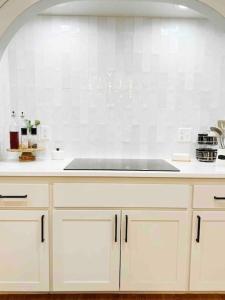 拉伯克NEW Magnolia Mansion-4400sqft Hot Tub & 2 Game Rms的厨房配有白色橱柜和水槽