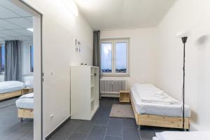 诺伊斯T&K Apartments 6 and 10 Room Apartment in Neuss for big Groups 22min to Fair DUS的带两张床和镜子的客房