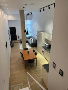 穆尔西亚Apartamento Murcia San José A的一间带木桌的客厅和一间厨房