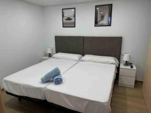 穆尔西亚Apartamento Murcia San José A的一间卧室配有一张带2个床头柜的大型白色床