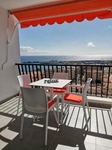 洛斯克里斯蒂亚诺斯Los Cristianos Achacay Appartement standing Vue panoramique的海景阳台上的桌椅