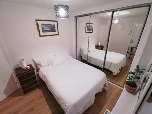 格拉斯哥Peaceful house in the heart of Glasgow city, close to Queen Elizabeth Hospital and Govan subway, Free Private Parking的一间小卧室,配有两张床和镜子