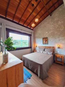 圣安娜杜里亚舒Casa do Lago Lapinha da Serra的一间卧室设有一张床和一个大窗户