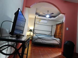 格拉纳达Casa El Caimito的客房设有一张床、一张桌子和一台电脑
