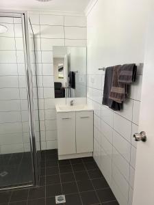 阿瑟顿阿瑟顿假日公园酒店的白色的浴室设有水槽和淋浴。