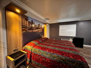 加迪纳市The Patio Motel - Los Angeles, LAX的一间卧室配有一张带彩色毯子的床