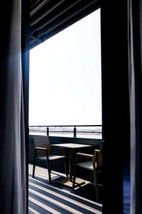 伊兹密尔Best Western Premier Karsiyaka Convention & Spa Hotel的海景阳台上的桌椅