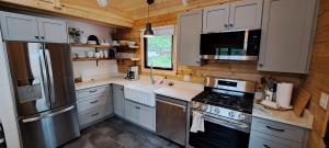 安蒂戈尼什Lochaber Homesteader Lodge的厨房配有白色橱柜和不锈钢冰箱