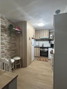 贝尔蒙特Casa Rural La Simona的厨房配有木制橱柜、桌子和冰箱。
