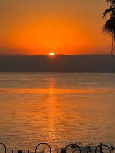 提比里亚בית על חוף כנרת的日落在一大片水面上