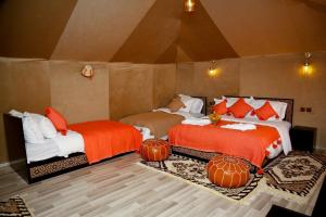 梅尔祖卡Luxury berber style的配有南瓜的房间的两张床,位于地板上