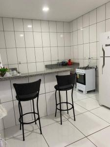 库亚巴apartamento inteiro的厨房配有两把椅子、一个柜台和一台冰箱