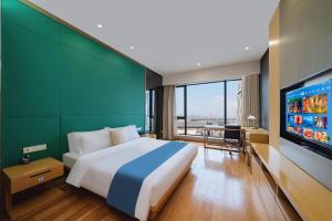 广州一呆公寓（广州保利世贸会展中心店）的一间卧室配有一张大床和一台平面电视