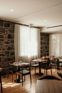 仙女港The Oak & Anchor Hotel的一间带桌椅和石墙的用餐室