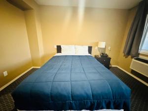 落基山庄Voyageur Motel的酒店客房,配有一张带蓝色毯子的床