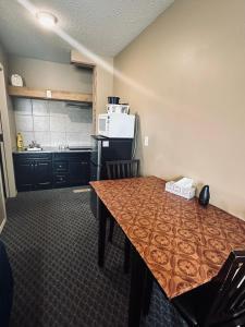 落基山庄Voyageur Motel的一间带桌子的厨房和一间带微波炉的厨房