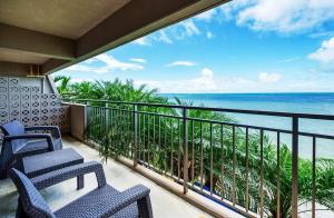 石垣岛GRANDVRIORESORT ISHIGAKIJIMA Ocean's Wing & Villa Garden的阳台配有椅子,享有海景。