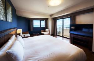 石垣岛GRANDVRIORESORT ISHIGAKIJIMA Ocean's Wing & Villa Garden的卧室配有白色大床和钢琴