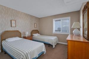 罗丹特7053 - Hatteras High 5C by Resort Realty的酒店客房设有两张床和窗户。