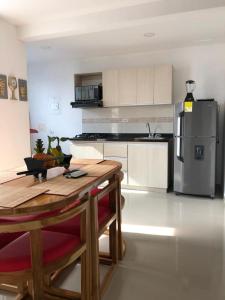 科韦尼亚斯Hermoso Apartamento en Caribe Campestre的厨房配有桌子和不锈钢冰箱。