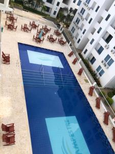 科韦尼亚斯Hermoso Apartamento en Caribe Campestre的享有大型蓝色游泳池的顶部景致,设有桌子