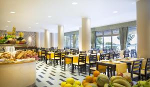 奥瑞比克阿米内斯格兰德阿祖尔酒店的用餐室配有黄色桌椅和食物