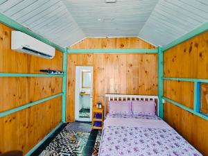 罗夷Coco Beachcamp La Gi的卧室配有一张床铺,位于带木墙的房间内